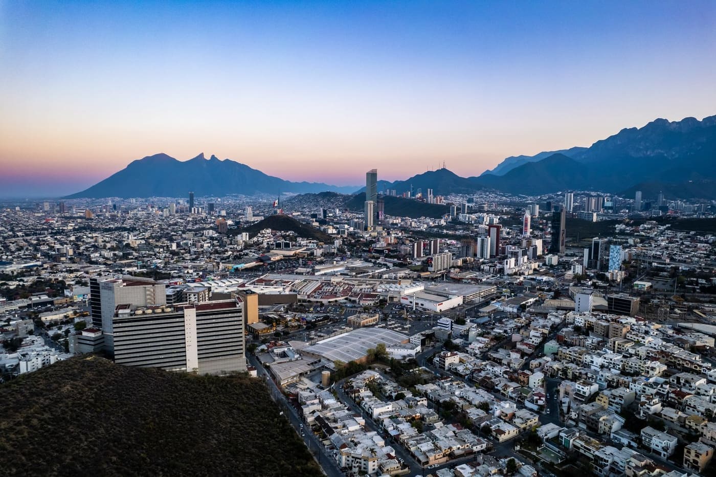 Ciudad del norte de México al anochecer, con la Sierra Madre al fondo